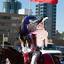 A woman dressed in red cowgirl gear rides a horse through a parade..jpg